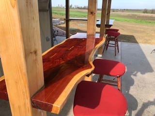 Wooden bar with red stools outdoors